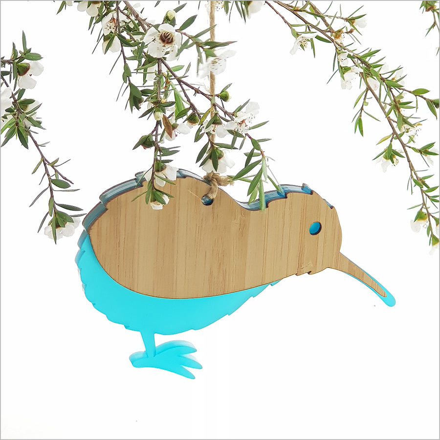 "Hanging Kiwi ornament crafted from bamboo and teal acrylic, featuring a laser-cut design, perfect for home decor."