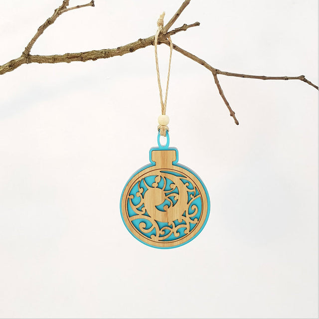 Teal satin acrylic hanging ornament with Koru design, perfect for festive decor or year-round elegance, ready to hang.