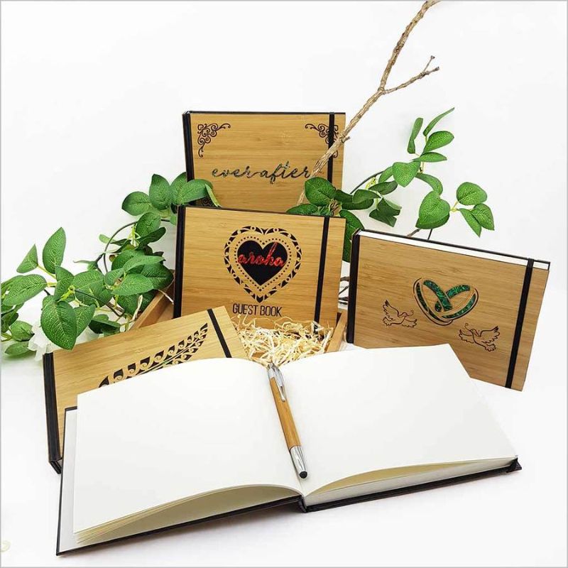 Hardbound guest book journal featuring intricate laser-cut bamboo design with NZ paua accents, perfect for capturing memories.