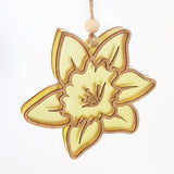 Hanging ornament featuring a daffodil flower in eco-friendly bamboo and vibrant yellow satin acrylic, perfect for home decor.