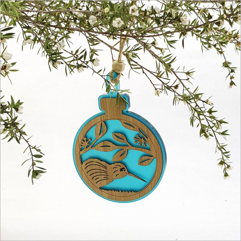 Hanging ornament featuring a kiwi on pohutukawa branch, crafted from teal satin acrylic and bamboo, perfect for Christmas decor.