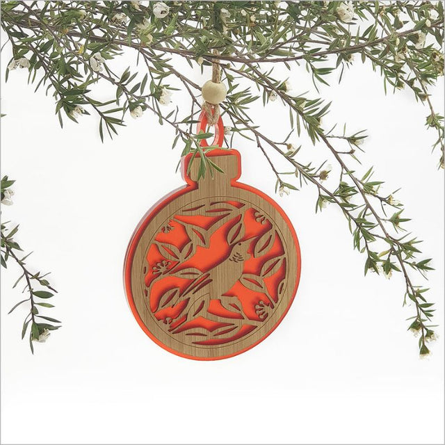 Red acrylic bauble ornament featuring a Tui on a Pohutukawa branch, perfect for festive decor or thoughtful gifts.