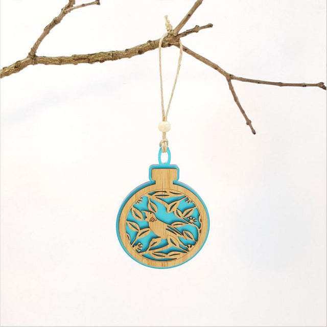 Acrylic bauble ornament featuring a Tui on Pohutukawa in teal, perfect for festive decor and gifts celebrating New Zealand.