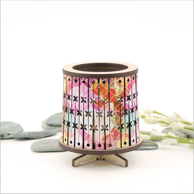 Round LED tealight holder made from laser-cut veneer, featuring a color-changing LED candle for a cozy ambiance.