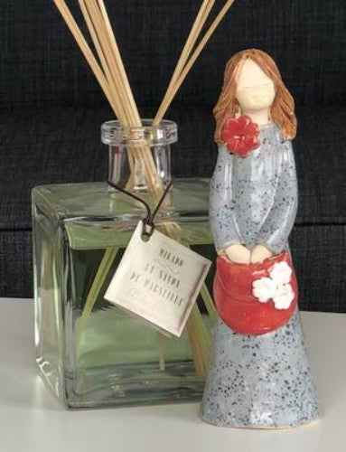 White clay girl ornament with a vibrant red bag, perfect for adding charm to any decor space, measuring 17cm in height.