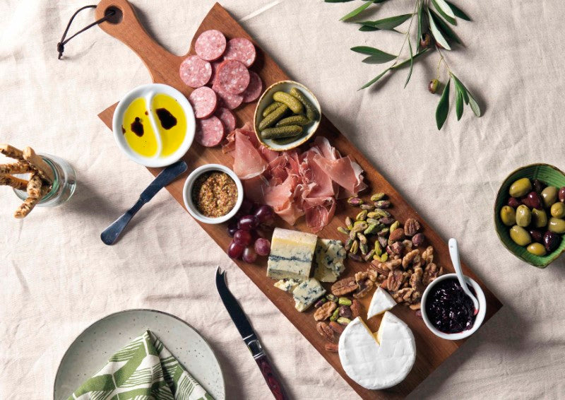 Elegant Acacia hardwood serving board with bevelled handle, unique grain, and leather loop for easy storage and display.
