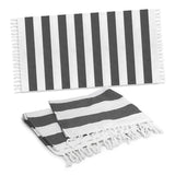 Charcoal cotton towel with a rustic weave, elegant stripes, and fringed trim, perfect for beach outings and picnics.