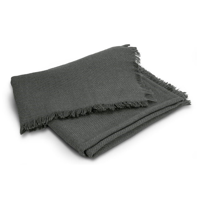 Luxurious charcoal throw blanket featuring herringbone design, eco-friendly fabric blend, and elegant fringe trim. Perfect for cozying up.