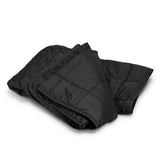 Cozy black puffer blanket with water-resistant fabric, plush foam fill, and convenient drawstring pouch for easy transport.