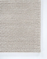 Warm beige handwoven 250x350cm rug featuring a knotted weave, blending wool, cotton, and polyester for stylish comfort.