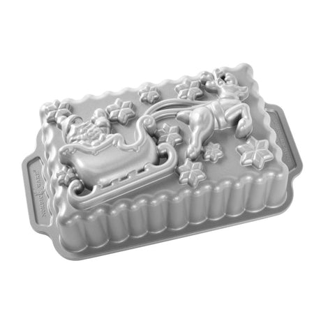 Loaf pan shaped like Santa's sleigh in sparkling silver, perfect for festive breads and desserts during the holiday season.