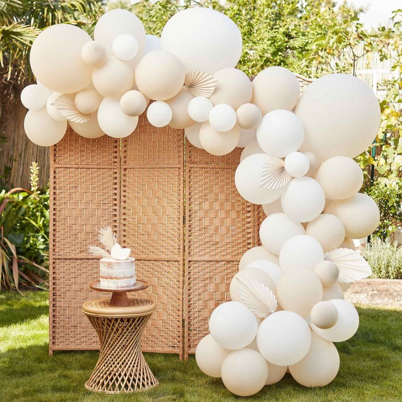 Nude and white balloon arch kit with 80 balloons and 5 cream paper fans, ideal for elegant celebrations and photo backdrops.