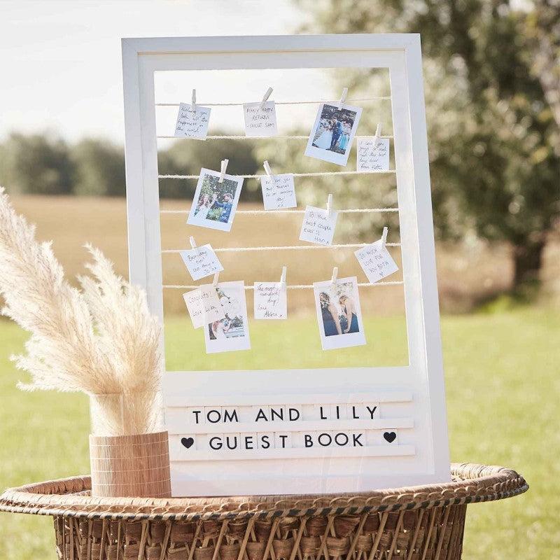 Botanical wedding guest book frame with pegs and twine, perfect for heartfelt messages and unique keepsake display.