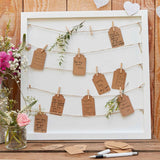 Rustic guest book frame with string, pegs, and tags for heartfelt messages at weddings and celebrations.