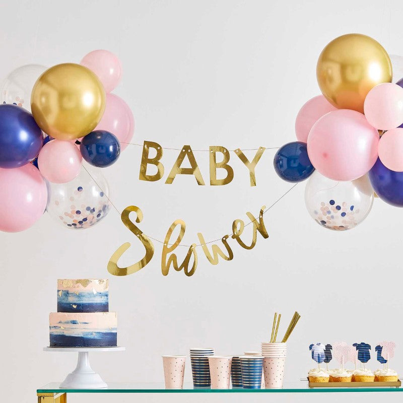 Gold foiled 'Baby Shower' bunting and 28 vibrant balloons in pink, navy, and gold for a chic gender reveal celebration.