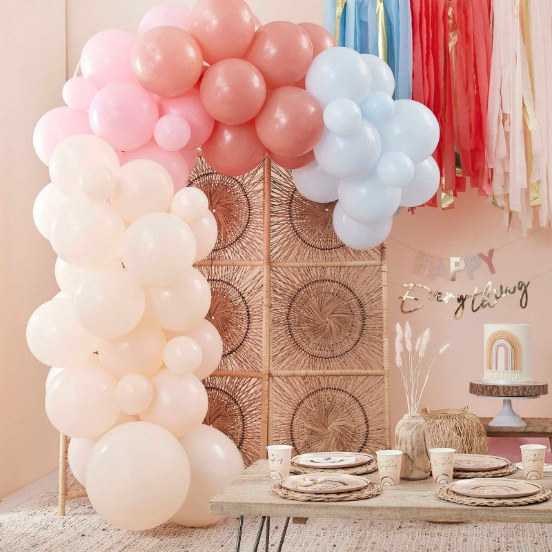 Pastel balloon arch backdrop featuring 75 balloons in peach, pink, and blue for vibrant party decorations.