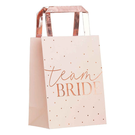 Stylish pink and rose gold foiled hen party bags with Team Bride design, perfect for carrying bachelorette essentials. Pack of 5.