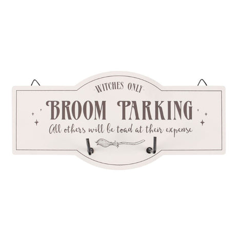 Whimsical wall hook sign with broom illustration and text 'Witches Only - Broom Parking' for organized witchy decor.