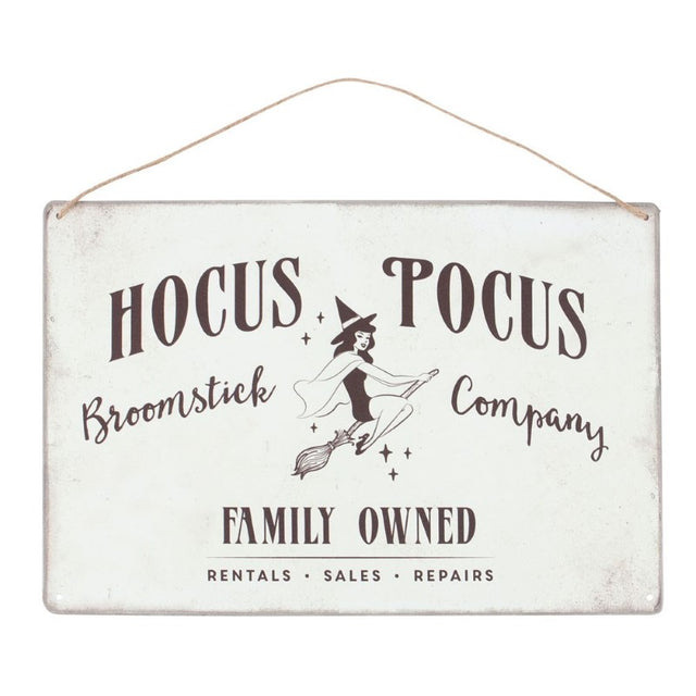 Retro metal sign featuring a pin-up witch illustration and 'Hocus Pocus Broomstick Company' text, ideal for Halloween decor.
