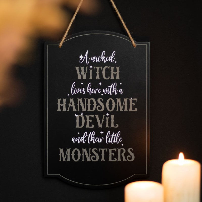 Whimsical Halloween sign featuring "A Wicked Witch Lives Here" text, perfect for family-friendly spooky decor.