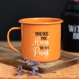 Whimsical orange enamel mug with 'You're The Hocus To My Pocus' text, perfect for witches' cozy brews and Halloween decor.