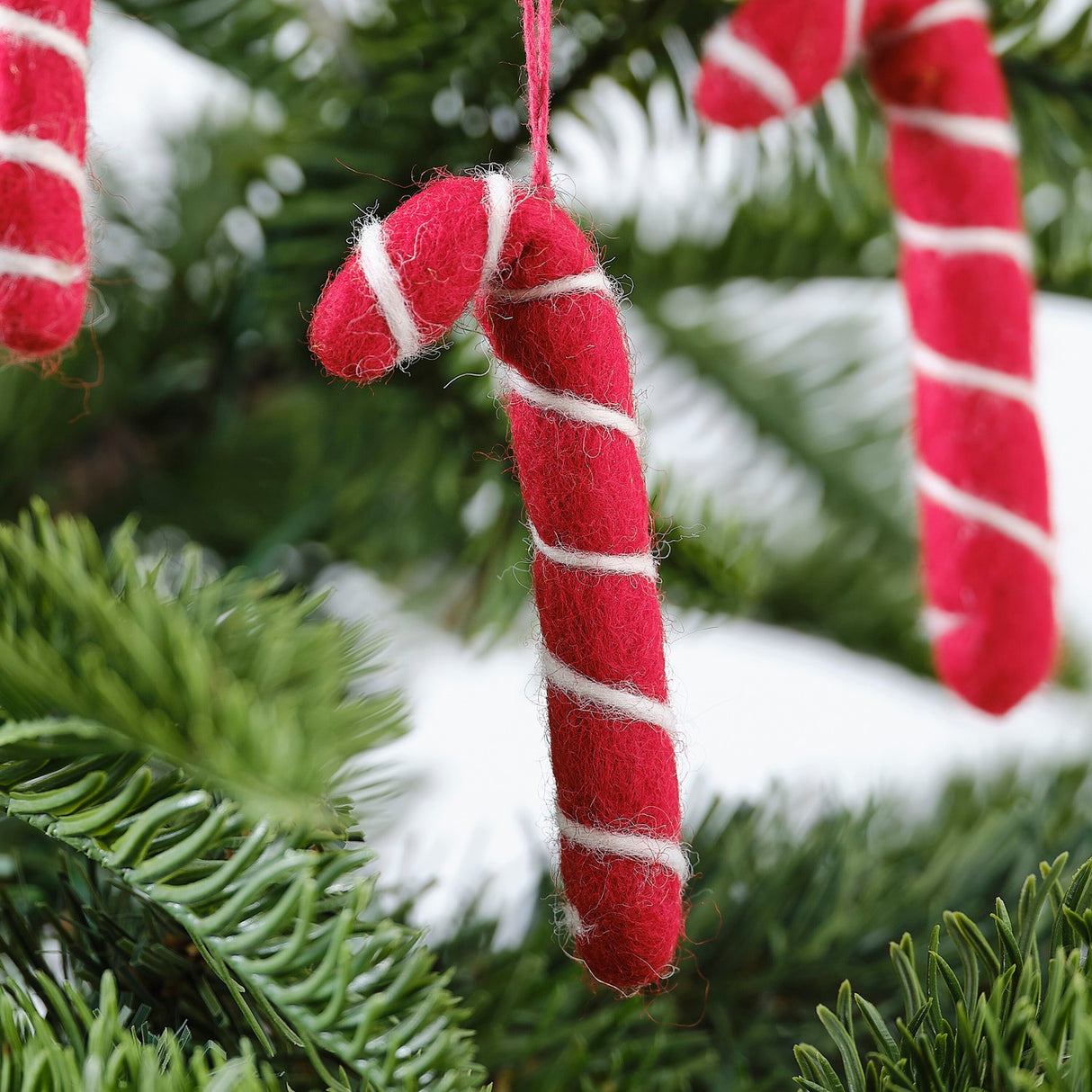 Handmade felt candy cane decorations, 8cm high, adorned with red twine, perfect for festive holiday decor.