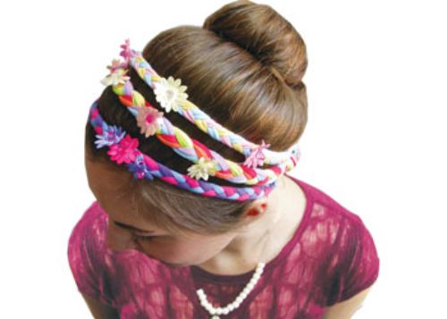 Colorful DIY hair accessory kit for kids, featuring fabric strips, flowers, beads, and elastic bands for creative hairstyles.