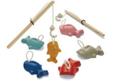 Colorful wooden fish and a magnetic rod in the sustainable PlanToys Fishing Game, promoting fun and learning for kids.