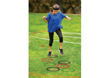 A vibrant ninja obstacle course set with bounce balls, hop sacks, ropes, rings, and crawl posts for fun, family competitions.