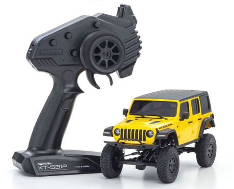 Kyosho MX-01 Wrangler Unlimited RC car in yellow with detailed body, 4x4 chassis, and 2.4GHz transmitter for all-terrain crawling.