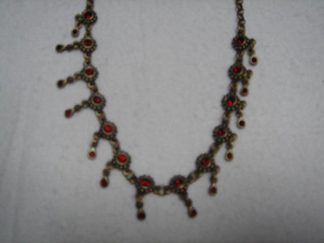 Brass chain necklace adorned with vibrant red Dia Flowers, perfect for adding color to any outfit.