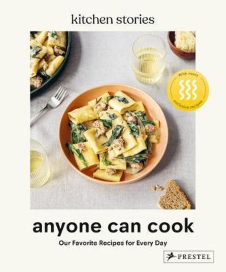 Hardcover cookbook "Anyone Can Cook" by Kitchen Stories, featuring 320 pages of easy, elegant recipes for all skill levels.