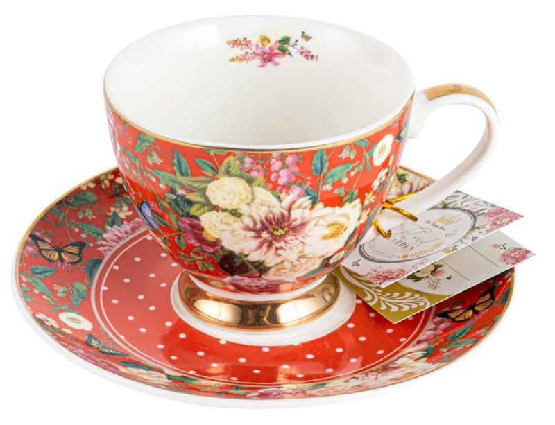 Delicate porcelain teacup and saucer set in rich red with floral patterns, perfect for tea enthusiasts and special occasions.