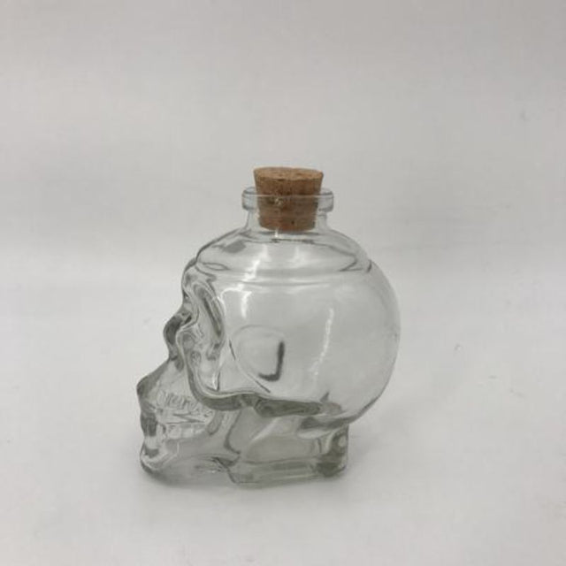 Set of 12 skull-shaped glass bottles, perfect for cocktails, unique decor, or themed parties, showcasing a bold design.