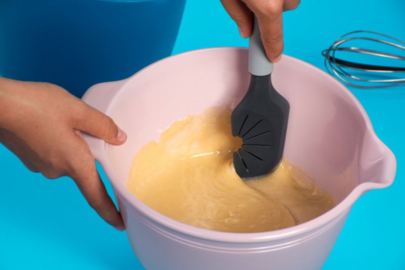 Silicone dough scraper with whisk cleaning function, non-stick, heat resistant, and soft-touch handle for easy baking.