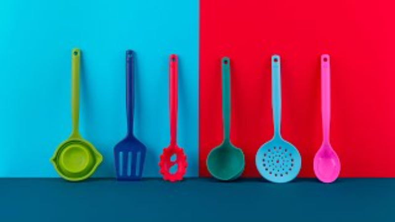 A vibrant silicone slotted turner with a serrated edge, designed for cooking and serving without scratching non-stick cookware.