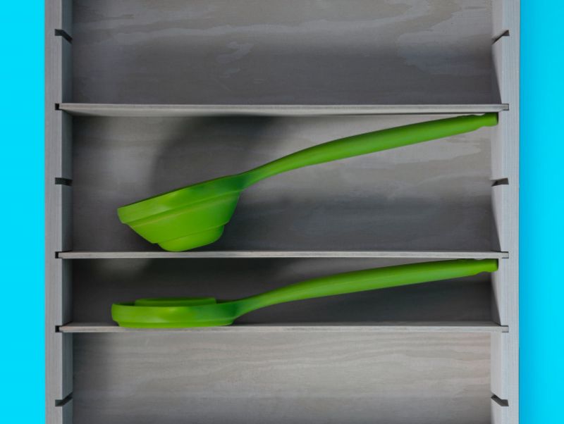 Collapsible green silicone ladle with dual pouring spouts, heat-resistant, and gentle on cookware for easy serving.