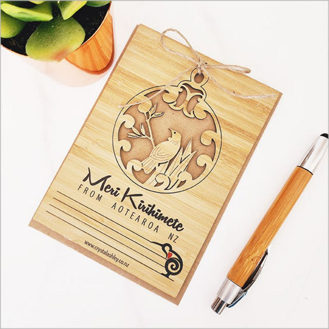 Eco-friendly bamboo postcard featuring a Tui motif, perfect for Kirihimete greetings and versatile hanging decor.