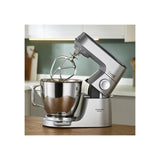 Silver Kenwood Titanium Chef Baker XL stand mixer with 7L bowl, 1200W motor, and multiple attachments for versatile baking.