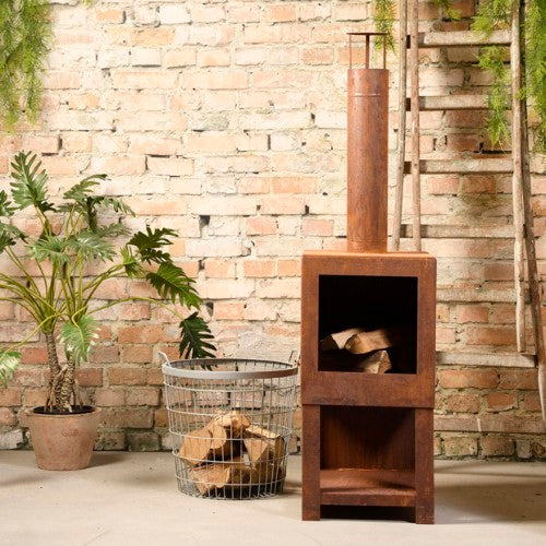 Rust-finished outdoor terrace heater with built-in wood storage, perfect for adding warmth and style to your garden.