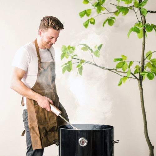 Stylish buffalo leather BBQ apron (104.5cm) with adjustable neck and snap buttons for comfort and protection while grilling.