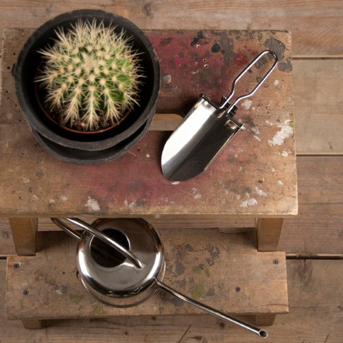 Compact foldable hand shovel made of stainless steel, ideal for small potting jobs and easy storage in tight spaces.