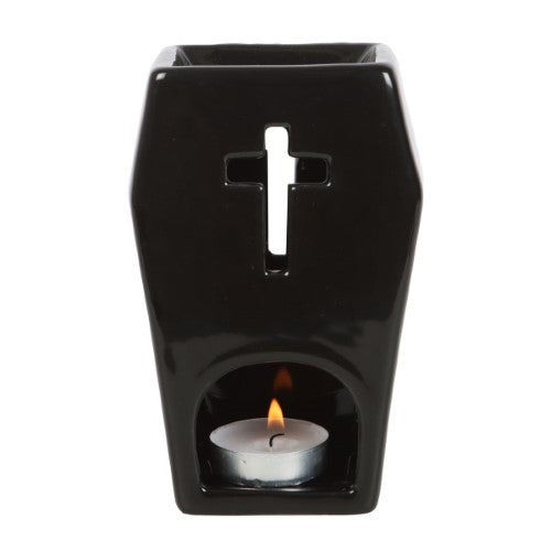 Coffin-shaped oil burner with cross cutouts, casting ambient light; perfect for gothic decor and aromatherapy.