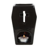 Coffin-shaped oil burner with cross cutouts, casting ambient light; perfect for gothic decor and aromatherapy.