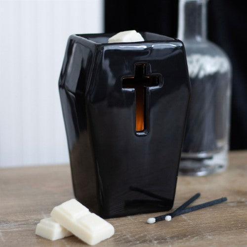 Coffin-shaped oil burner with cross cutouts, illuminating ambient light; perfect for gothic decor and aromatherapy.
