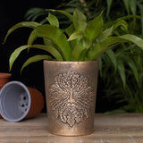 "Intricate Green Man design on bronze-finished terracotta plant pot, ideal for enhancing indoor or outdoor gardens."