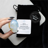 Iridescent opalite crystal skull, 4x5x2 cm, ideal for meditation and as a stylish desk accessory, presented in a drawstring pouch.