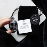Black Labradorite Crystal Skull, a 4x5x2 cm spiritual accessory for grounding, protection, and decor, in a chic black pouch.
