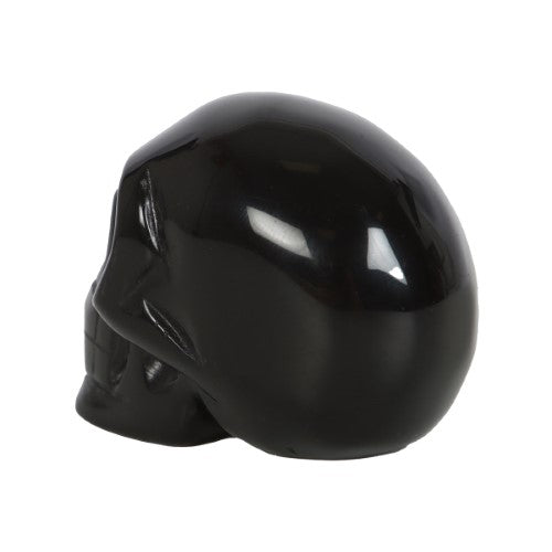 Handcrafted black obsidian crystal skull, 4x5x2 cm, perfect for decor, protection, and crystal healing, presented in a pouch.