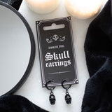 Black stainless steel earrings featuring intricate skull charms, perfect for gothic style and modern elegance.